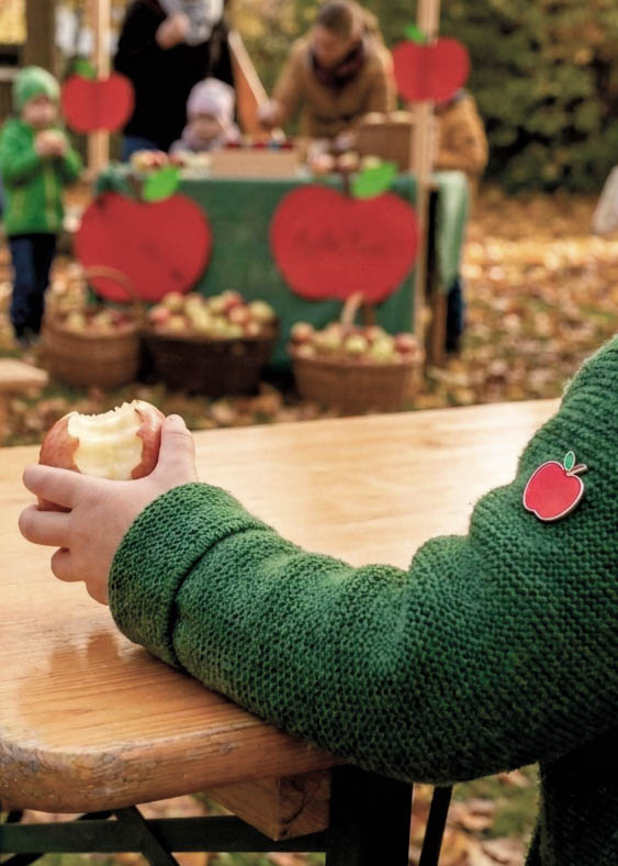Kinder tragen gemeinsam individuelle Apfel-Pins