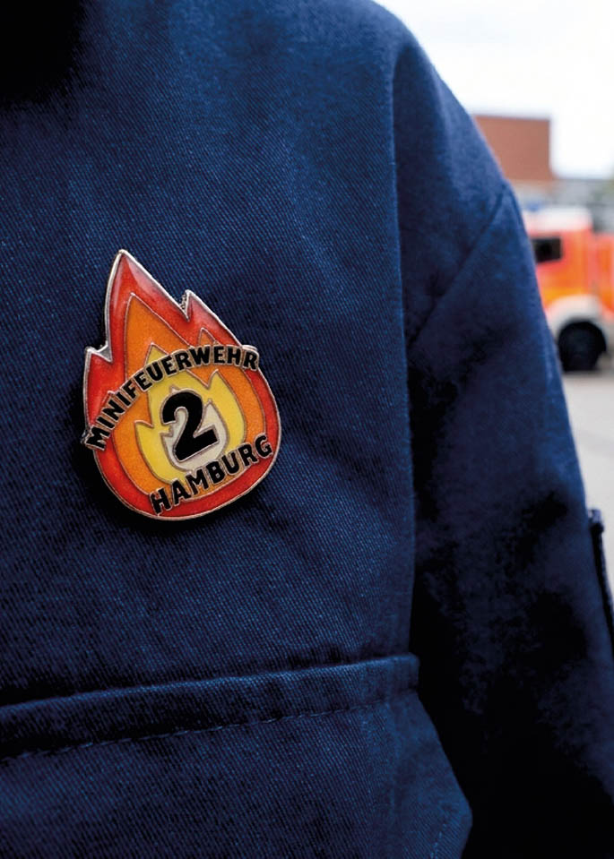Individueller Feuerwehr-Pin auf der Kleidung eines Kindes